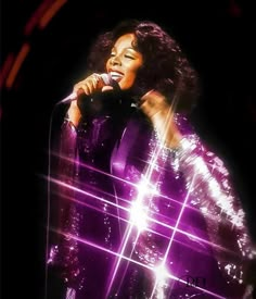 an image of a woman that is singing into a microphone in front of some lights