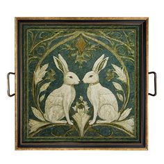 two white rabbits sitting next to each other on a green and gold tile wall hanging