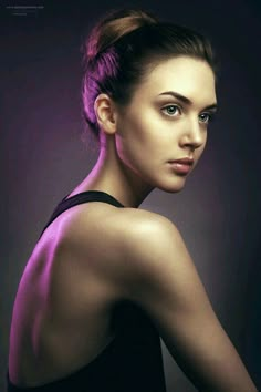 a woman with purple hair is posing for a photo in front of a dark background