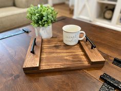 a wooden tray with a coffee cup on top of it next to a pair of scissors