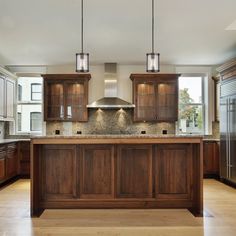 a large kitchen with wooden cabinets and an island in front of the stove top oven