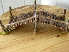 a piece of wood sitting on top of a wooden table covered in grass and twigs