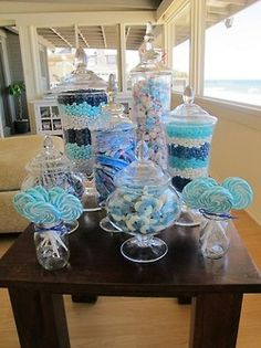 a table topped with lots of blue and white candy