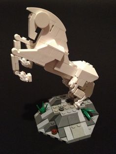 a lego model of an animal on top of a black surface with other items around it