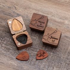 three wooden boxes with different types of guitar picks in them on a wood table top