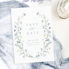 a wedding save the date card sitting on top of a table next to silverware