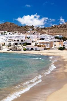 the beach is lined with white buildings and blue water