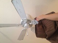 a person holding a bag and a ceiling fan