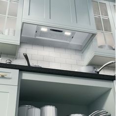 an open cabinet in a kitchen with pots and pans