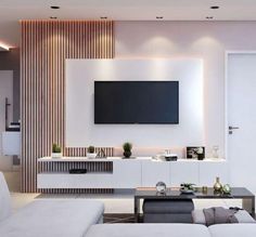 a living room with white furniture and a flat screen tv mounted on the wall above it