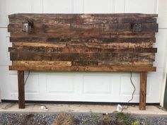 a wooden bench sitting in front of a garage door with two lights on it's sides