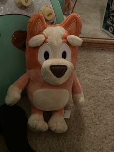 an orange and white stuffed animal sitting on top of a floor next to a mirror