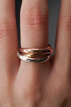 a woman's hand with two different rings on her fingers, one in gold and the other in silver