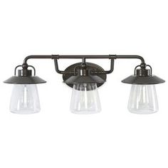 three light bathroom fixture with clear glass shades on an old - fashioned style wall mount