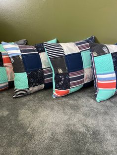 four decorative pillows are lined up on the floor