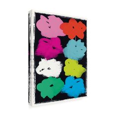 a book with different colored flowers on the front and back cover, in black background