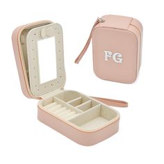 an open pink jewelry box with the lid opened to show compartments for makeup and accessories