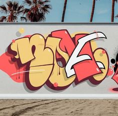 a man riding a skateboard past a graffiti covered wall