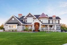 a large house with lots of windows on the front and side of it, surrounded by green grass