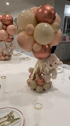 there are balloons and teddy bears on the table at this wedding reception with gold cutlery