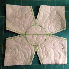 a piece of white fabric sitting on top of a green cutting board next to scissors