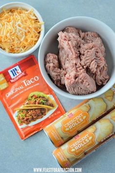 ingredients to make taco salad laid out in bowls on a blue counter top, including ground beef, shredded cheese and tortilla chips