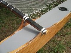 a close up of a wooden bench with a net on it's back end