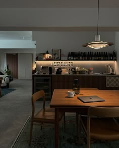 a dining room table with two chairs and a laptop on top of it in front of a bar