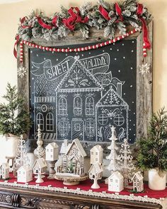 a chalk board with christmas decorations on it and a holiday scene in front of it