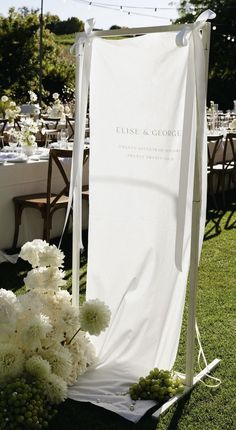 an outdoor ceremony setup with white flowers and greenery