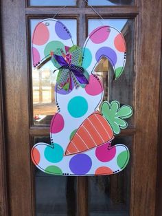 a door hanger decorated with polka dots and an image of a bunny holding a carrot