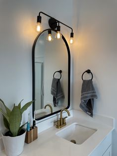 a bathroom sink with a mirror and lights above it