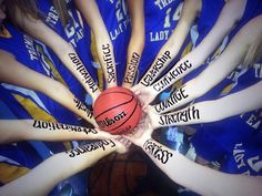 a group of young people holding a basketball in their hands with words written on them