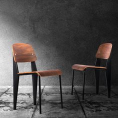 two wooden chairs sitting next to each other