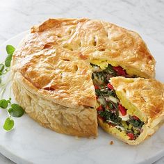 there is a pie that has been cut in half on a plate with green leaves