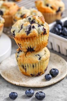 blueberry muffins stacked on top of each other with fresh blueberries in the background