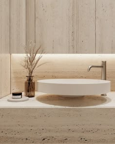 a white sink sitting on top of a counter next to a vase with flowers in it