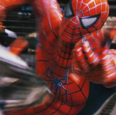 a spider man is in motion with his hands up