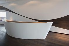 a large white bath tub sitting on top of a wooden floor