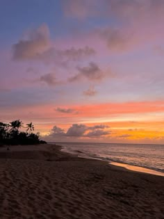 the sun is setting at the beach with palm trees