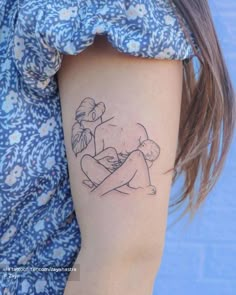 a woman's arm with a small tattoo on it that has a drawing of a girl hugging a boy