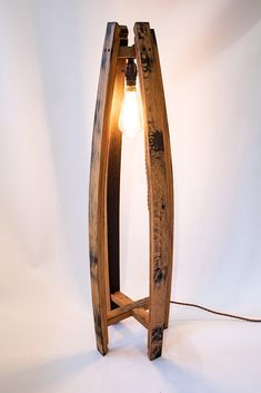 a lamp made out of wood with a light bulb on the end and a cord attached to it