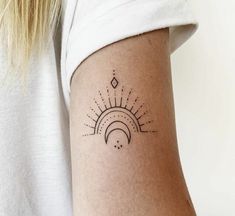 a woman's arm with a tattoo on it that has sun and moon in the middle