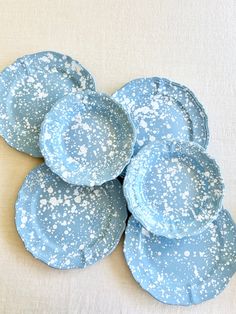 four blue plates with white speckles on them