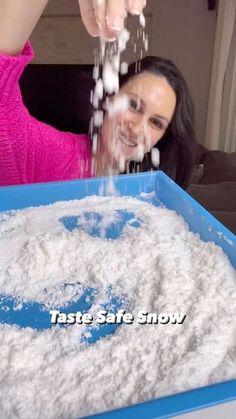 a woman is sprinkling sugar on her face in front of a blue tray