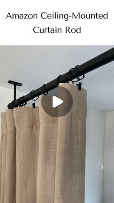 the curtain rod is attached to an open window in front of curtains with black hardware