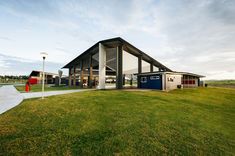 a large building sitting on top of a lush green field next to a parking lot