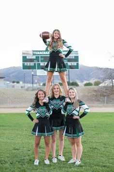 a group of cheerleaders standing on top of each other in front of a sign