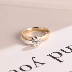 a diamond ring sitting on top of a book