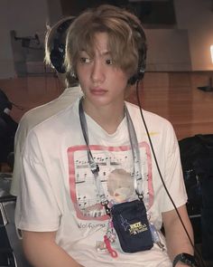 a boy with headphones on sitting in a chair